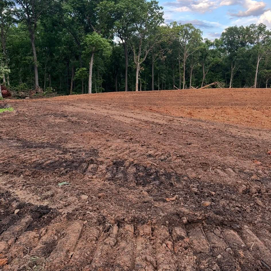 Operator view of site-prep grading through rural fields near Windsor, MO