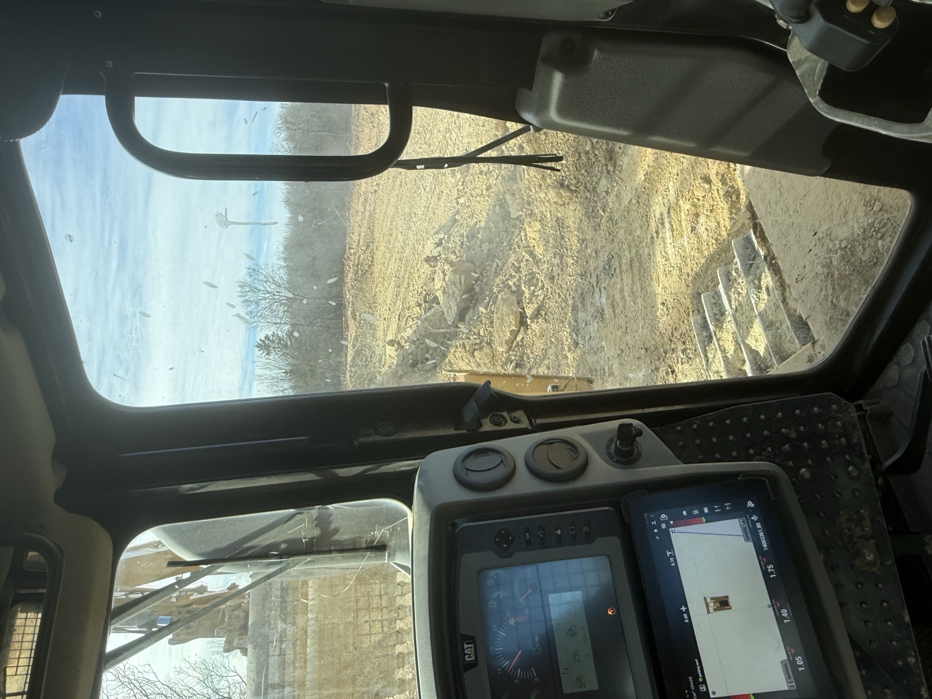 Operator cab view during grading and site-prep near Windsor, MO