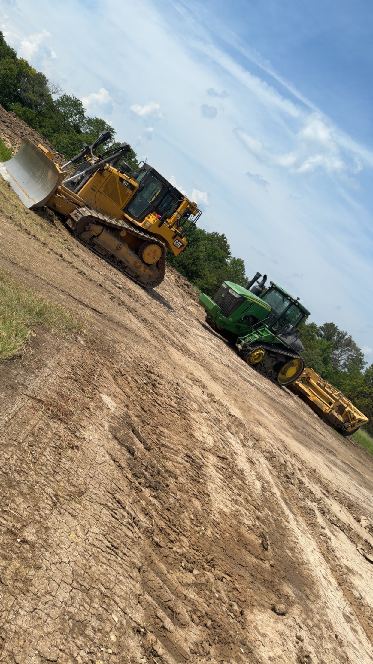CAT bulldozer and tracked scraper grading land in Henry County, Missouri
